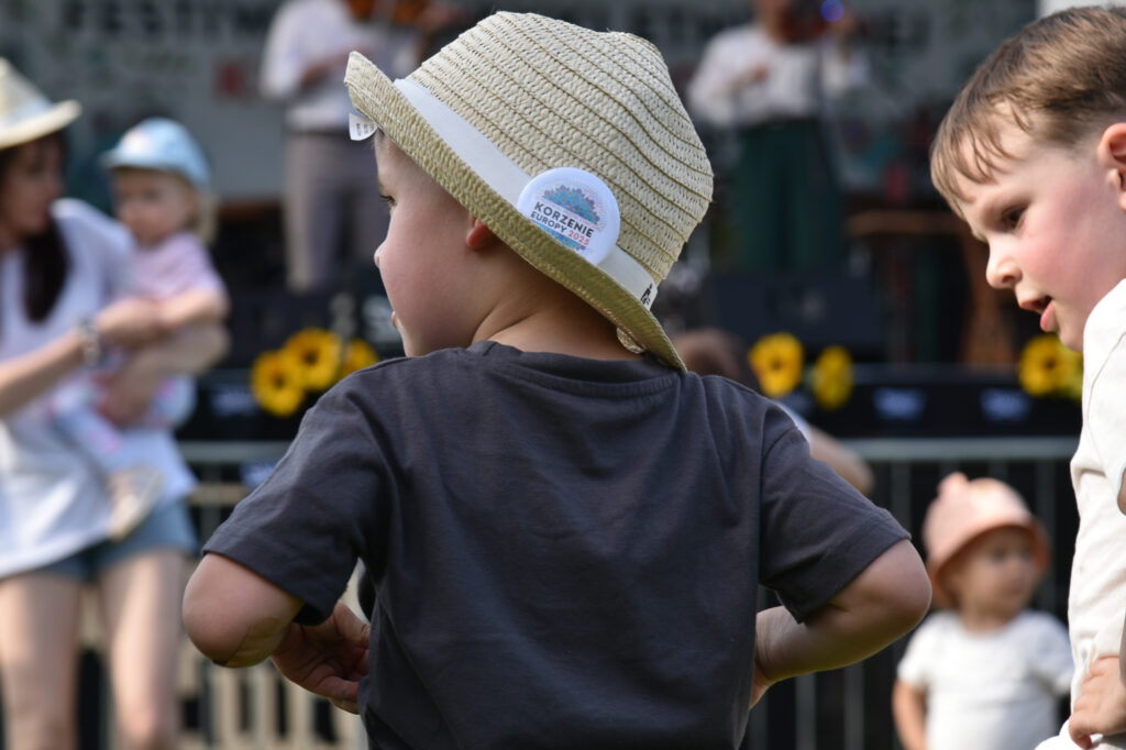 Zdjęcia z Festowalu KOrzenie Europy. Na zdjęciach widoczni są artyści na scenie, prowadzący koncert , publiczność i otoczenie koncertu - Park Bródnowski.