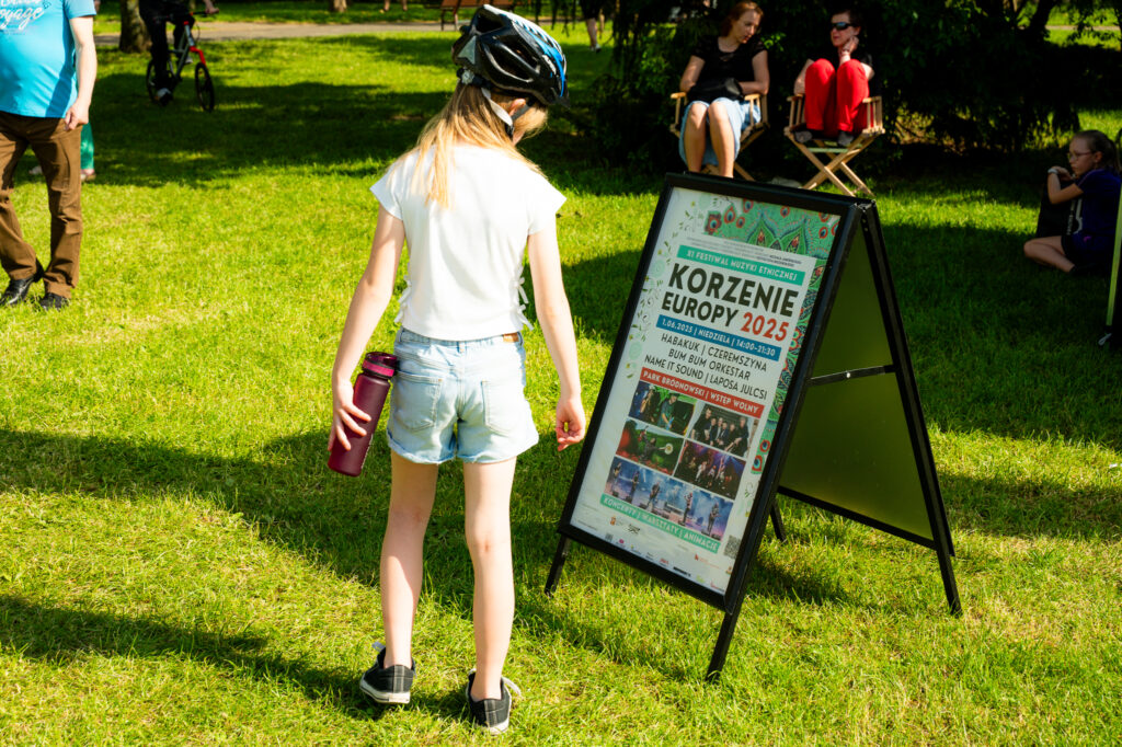 Zdjęcia z Festowalu KOrzenie Europy. Na zdjęciach widoczni są artyści na scenie, prowadzący koncert , publiczność i otoczenie koncertu - Park Bródnowski.