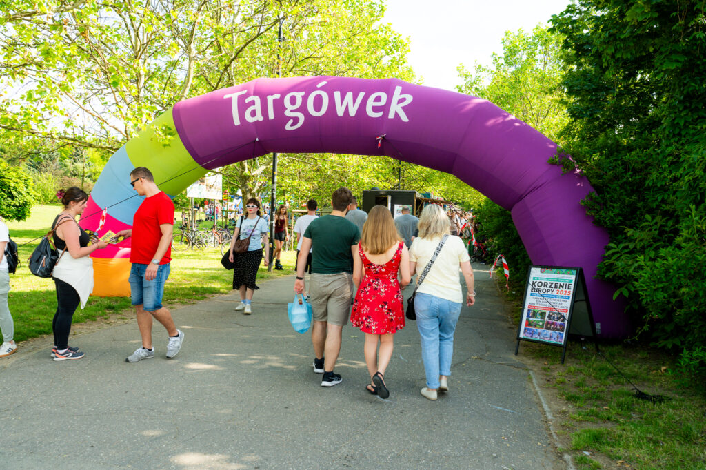 Zdjęcia z Festowalu KOrzenie Europy. Na zdjęciach widoczni są artyści na scenie, prowadzący koncert , publiczność i otoczenie koncertu - Park Bródnowski.