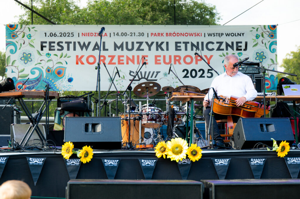 Zdjęcia z Festowalu KOrzenie Europy. Na zdjęciach widoczni są artyści na scenie, prowadzący koncert , publiczność i otoczenie koncertu - Park Bródnowski.