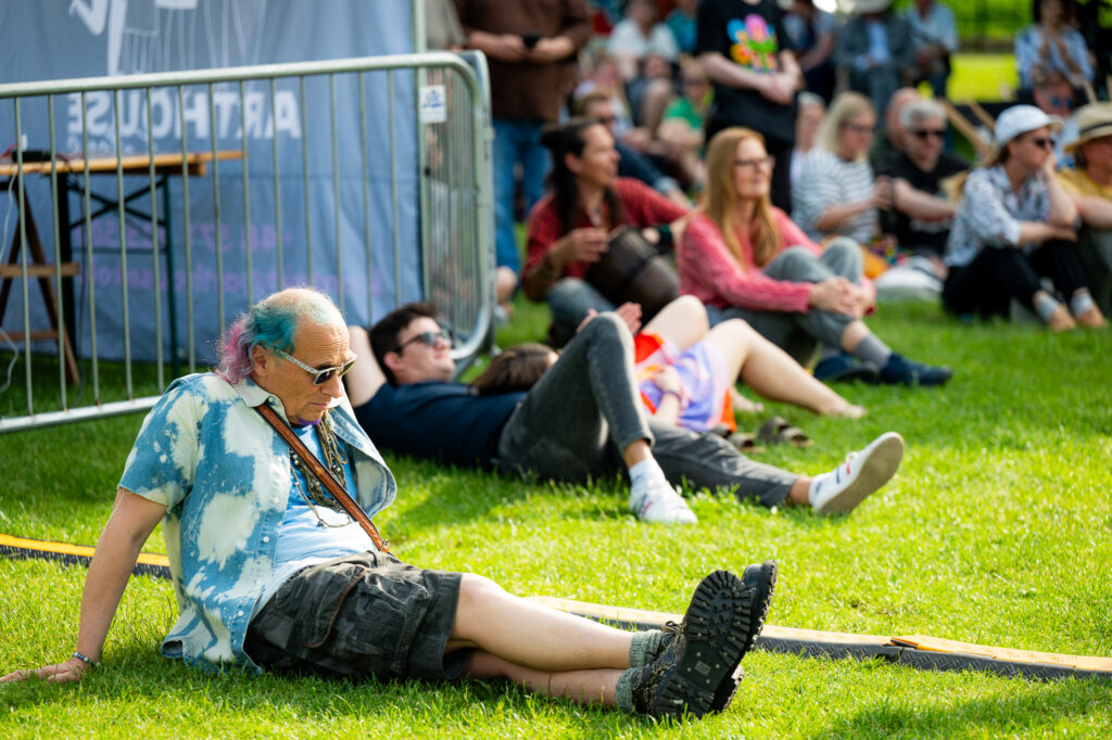 Zdjęcia z Festowalu KOrzenie Europy. Na zdjęciach widoczni są artyści na scenie, prowadzący koncert , publiczność i otoczenie koncertu - Park Bródnowski.