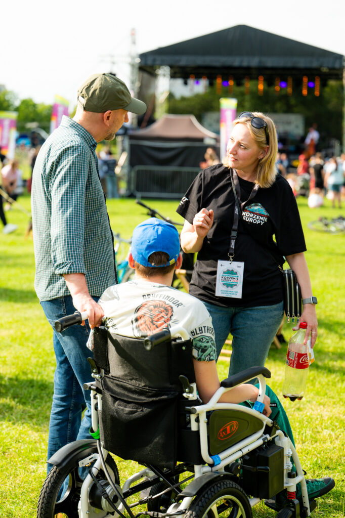 Zdjęcia z Festowalu KOrzenie Europy. Na zdjęciach widoczni są artyści na scenie, prowadzący koncert , publiczność i otoczenie koncertu - Park Bródnowski.
