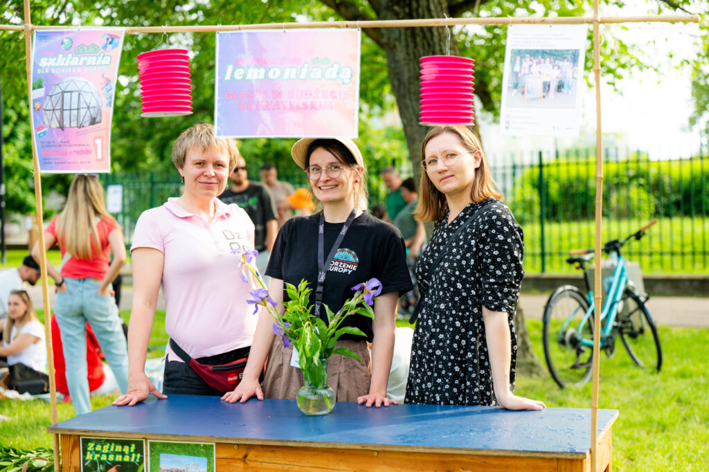 Zdjęcia z Festowalu KOrzenie Europy. Na zdjęciach widoczni są artyści na scenie, prowadzący koncert , publiczność i otoczenie koncertu - Park Bródnowski.