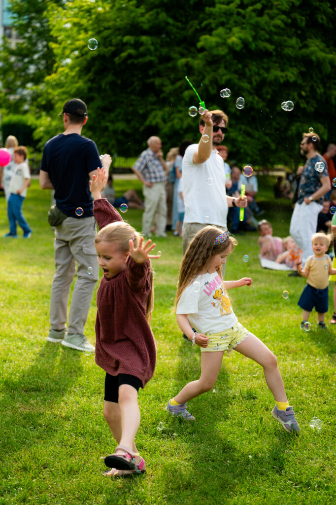 Zdjęcia z Festowalu KOrzenie Europy. Na zdjęciach widoczni są artyści na scenie, prowadzący koncert , publiczność i otoczenie koncertu - Park Bródnowski.