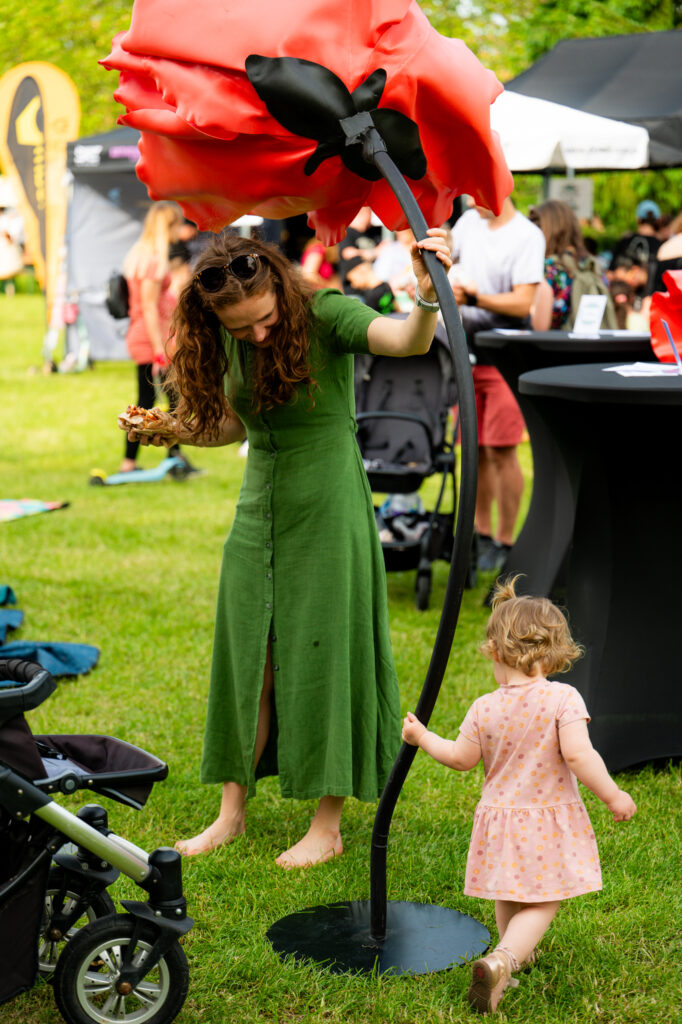 Zdjęcia z Festowalu KOrzenie Europy. Na zdjęciach widoczni są artyści na scenie, prowadzący koncert , publiczność i otoczenie koncertu - Park Bródnowski.
