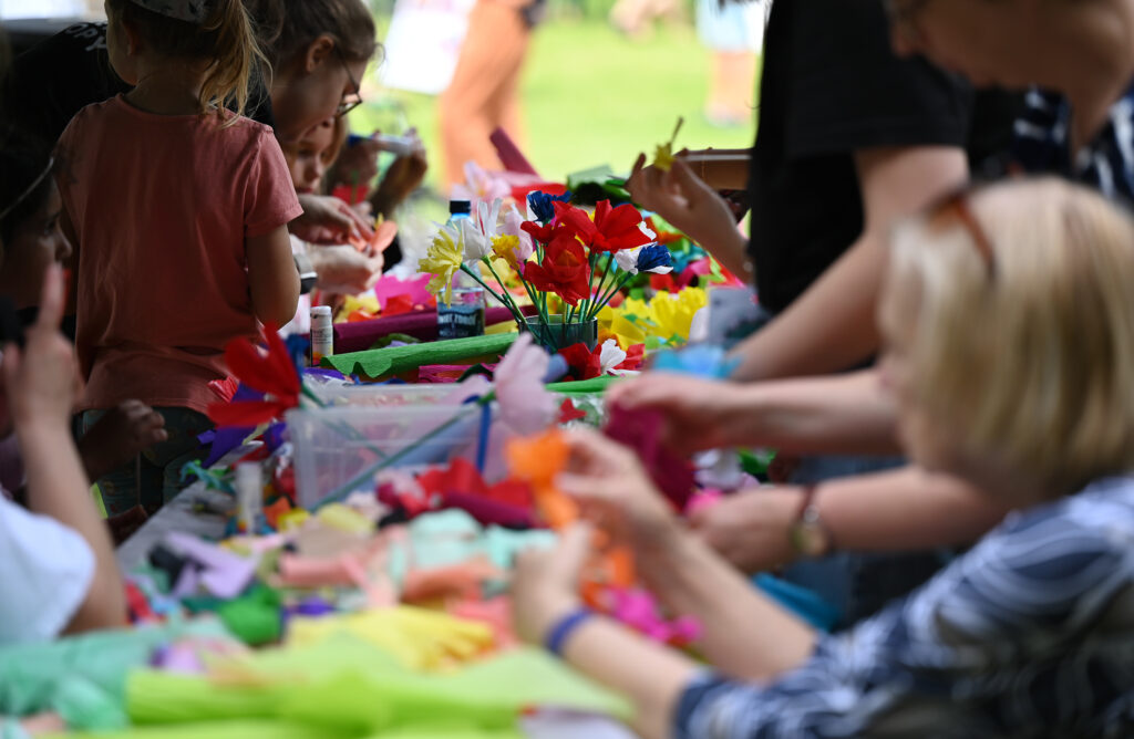 Zdjęcia z Festowalu KOrzenie Europy. Na zdjęciach widoczni są artyści na scenie, prowadzący koncert , publiczność i otoczenie koncertu - Park Bródnowski.