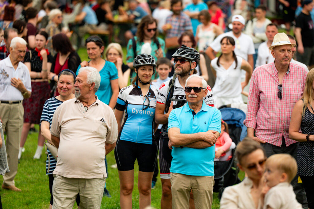 Zdjęcia z Festowalu KOrzenie Europy. Na zdjęciach widoczni są artyści na scenie, prowadzący koncert , publiczność i otoczenie koncertu - Park Bródnowski.