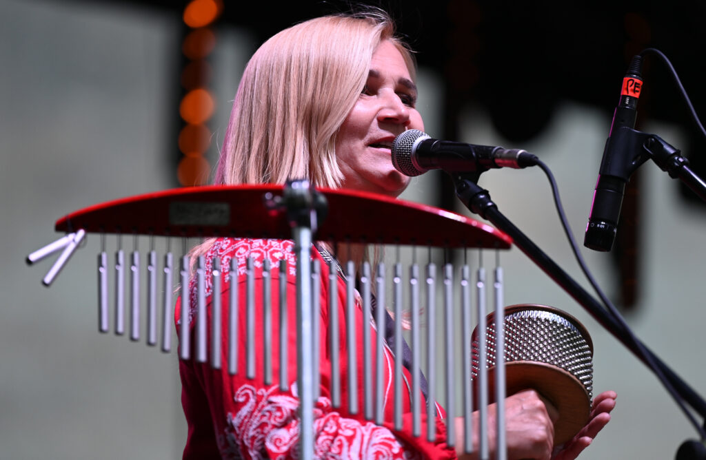 Zdjęcia z Festowalu KOrzenie Europy. Na zdjęciach widoczni są artyści na scenie, prowadzący koncert , publiczność i otoczenie koncertu - Park Bródnowski.