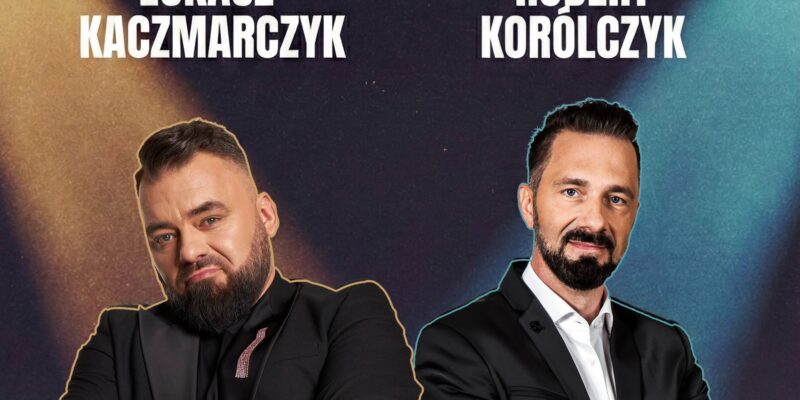 Dwóch uśmiechniętych mężczyzn z brodami stoi z założonymi rękami w czarnych garniturach. Nad nimi widoczne są napisy: Łukasz Kaczmarczyk oraz Robert Korólczyk.