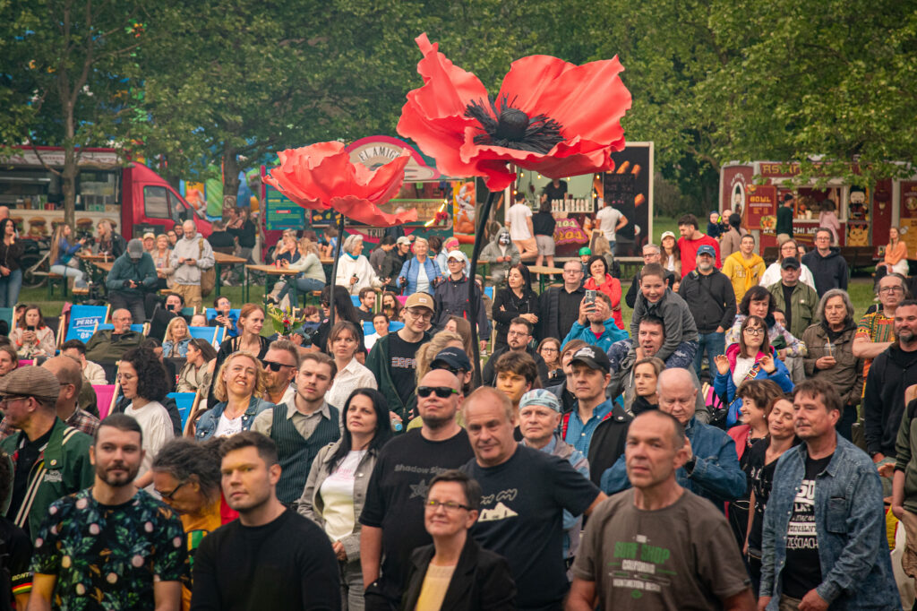 Zdjęcia z XII Festiwalu Muzyki Etnicznej Korzenie Europy, który się odbył 31 maja 2026 r. w Parku Bródnowskich. Na zdjęciach scena plenerowa, zespoły muzyczne, organizatorzy i publiczność w otoczeniu zieleni parku.