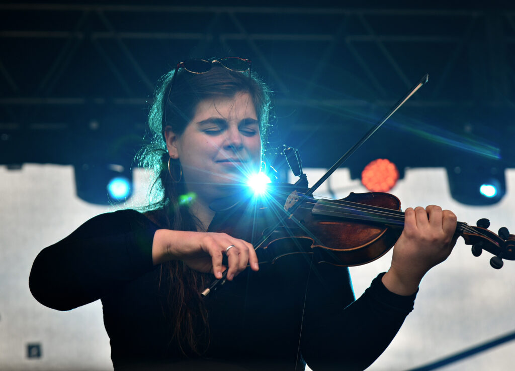 Zdjęcia z XII Festiwalu Muzyki Etnicznej Korzenie Europy, który się odbył 31 maja 2026 r. w Parku Bródnowskich. Na zdjęciach scena plenerowa, zespoły muzyczne, organizatorzy i publiczność w otoczeniu zieleni parku.
