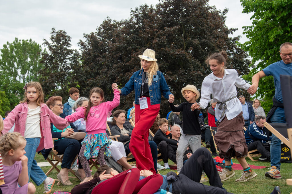 Zdjęcia z XII Festiwalu Muzyki Etnicznej Korzenie Europy, który się odbył 31 maja 2026 r. w Parku Bródnowskich. Na zdjęciach scena plenerowa, zespoły muzyczne, organizatorzy i publiczność w otoczeniu zieleni parku.