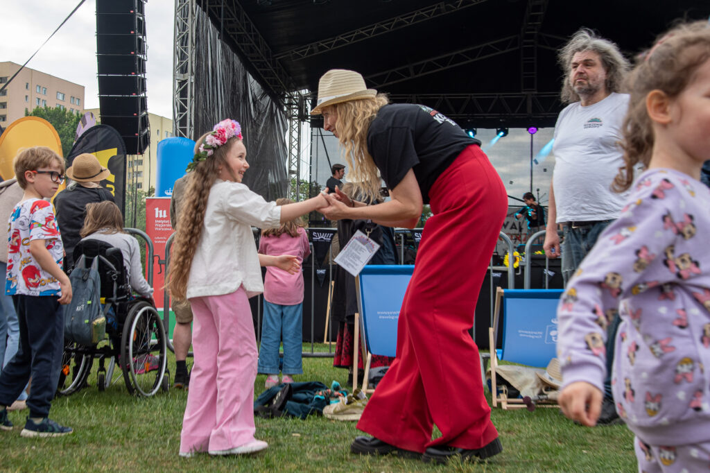 Zdjęcia z XII Festiwalu Muzyki Etnicznej Korzenie Europy, który się odbył 31 maja 2026 r. w Parku Bródnowskich. Na zdjęciach scena plenerowa, zespoły muzyczne, organizatorzy i publiczność w otoczeniu zieleni parku.