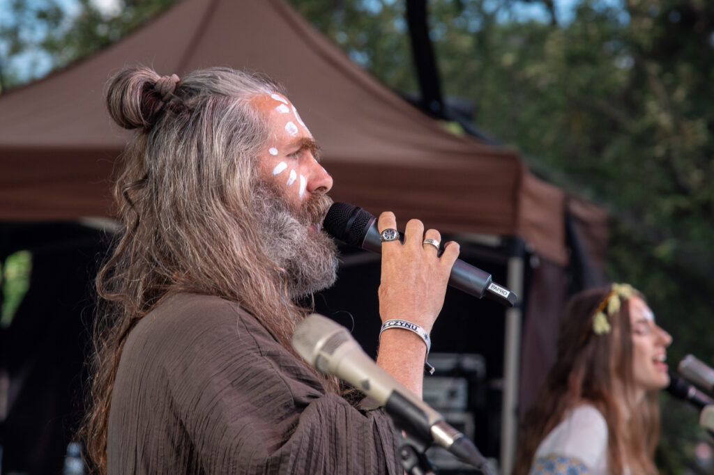 Zdjęcia z XII Festiwalu Muzyki Etnicznej Korzenie Europy, który się odbył 31 maja 2026 r. w Parku Bródnowskich. Na zdjęciach scena plenerowa, zespoły muzyczne, organizatorzy i publiczność w otoczeniu zieleni parku.