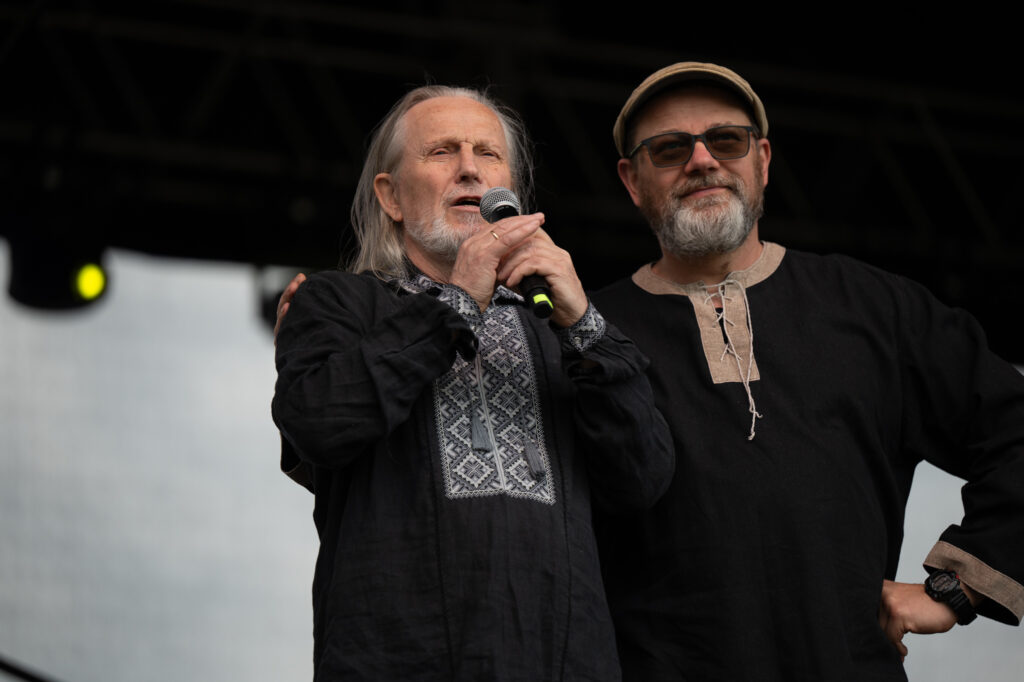 Zdjęcia z XII Festiwalu Muzyki Etnicznej Korzenie Europy, który się odbył 31 maja 2026 r. w Parku Bródnowskich. Na zdjęciach scena plenerowa, zespoły muzyczne, organizatorzy i publiczność w otoczeniu zieleni parku.