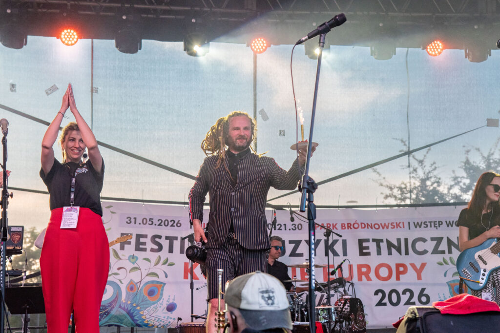 Zdjęcia z XII Festiwalu Muzyki Etnicznej Korzenie Europy, który się odbył 31 maja 2026 r. w Parku Bródnowskich. Na zdjęciach scena plenerowa, zespoły muzyczne, organizatorzy i publiczność w otoczeniu zieleni parku.