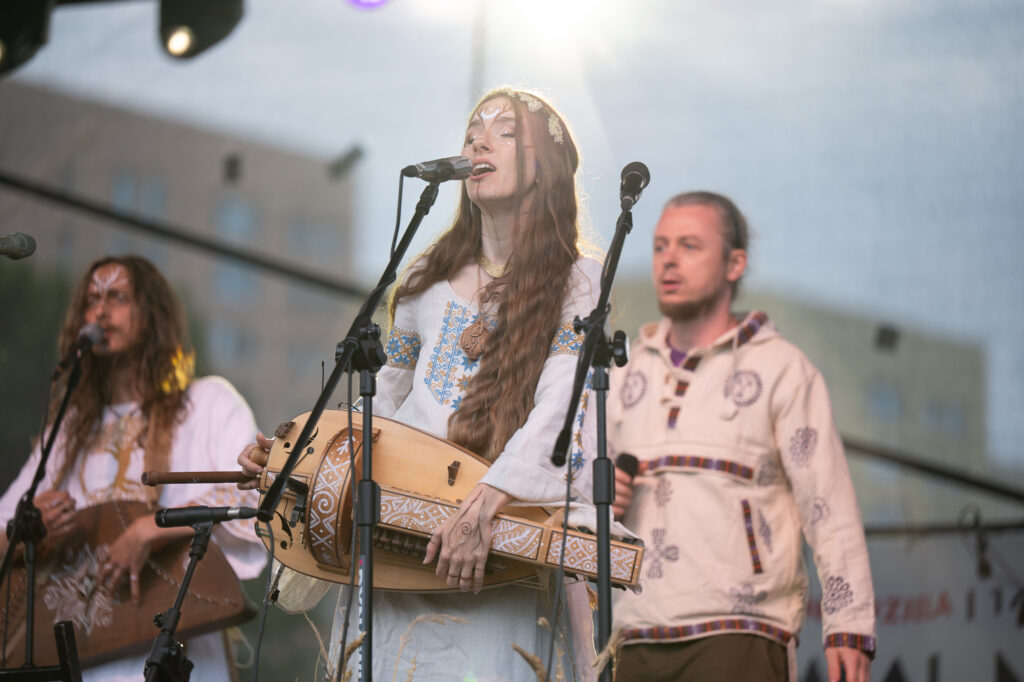 Zdjęcia z XII Festiwalu Muzyki Etnicznej Korzenie Europy, który się odbył 31 maja 2026 r. w Parku Bródnowskich. Na zdjęciach scena plenerowa, zespoły muzyczne, organizatorzy i publiczność w otoczeniu zieleni parku.
