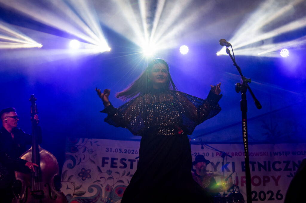 Zdjęcia z XII Festiwalu Muzyki Etnicznej Korzenie Europy, który się odbył 31 maja 2026 r. w Parku Bródnowskich. Na zdjęciach scena plenerowa, zespoły muzyczne, organizatorzy i publiczność w otoczeniu zieleni parku.