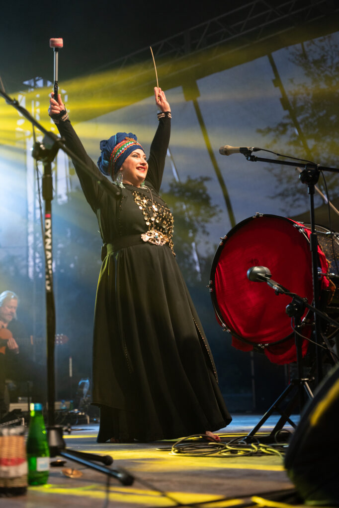 Zdjęcia z XII Festiwalu Muzyki Etnicznej Korzenie Europy, który się odbył 31 maja 2026 r. w Parku Bródnowskich. Na zdjęciach scena plenerowa, zespoły muzyczne, organizatorzy i publiczność w otoczeniu zieleni parku.
